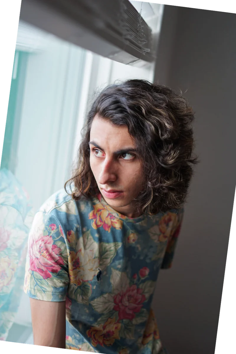 Portrait by a window, wearing a floral shirt